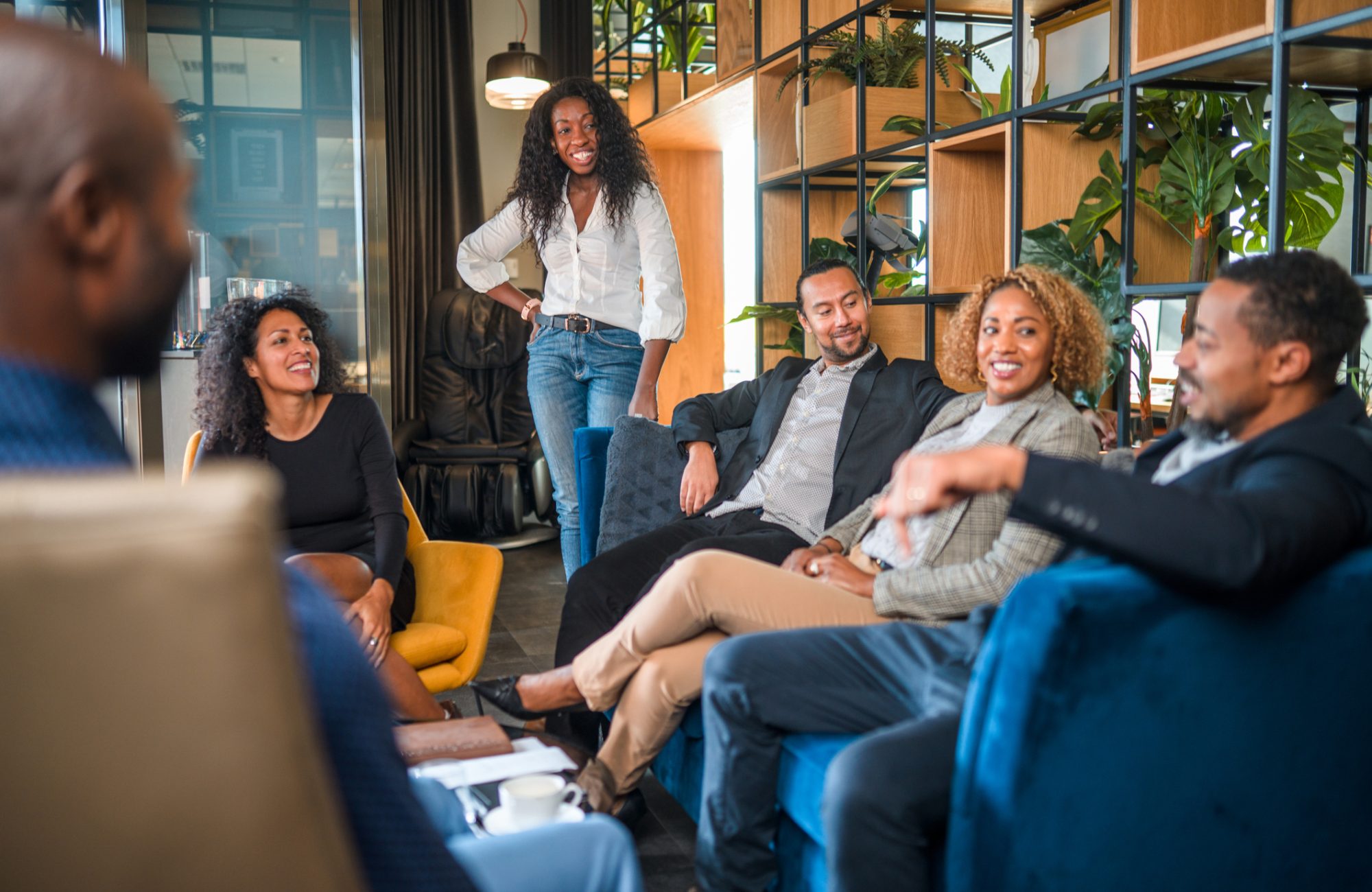 Diverse business associates relaxing and exchanging ideas in a sitting area of a modern office.